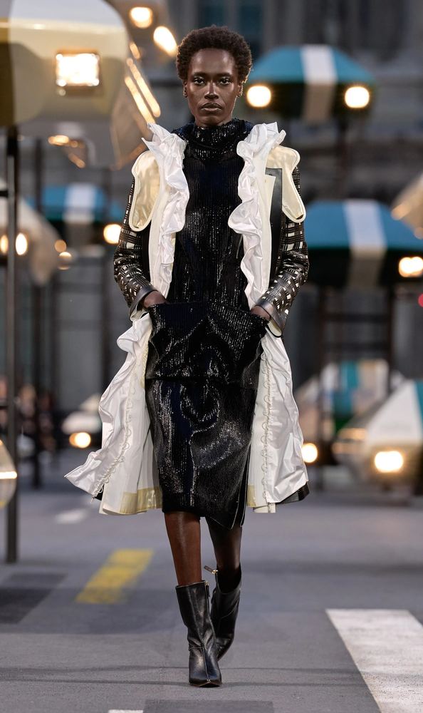 Black sequined dress under an ivory ruffled coat, Louis Vuitton S/S 27, Paris.