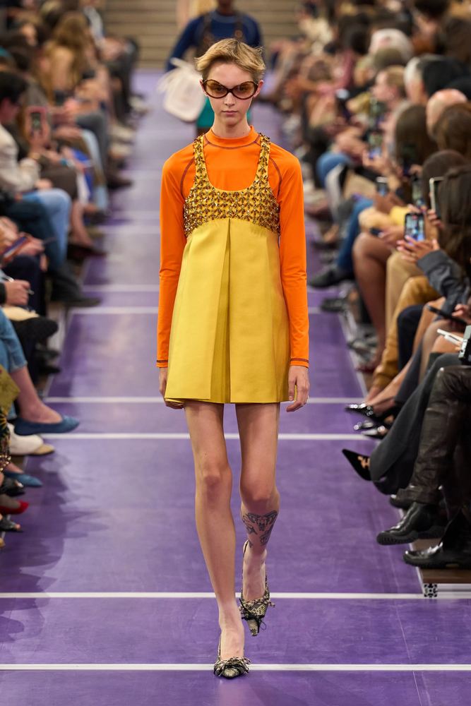 Yellow minidress with a beaded bib over an orange top, Miu Miu S/S 27, Paris.