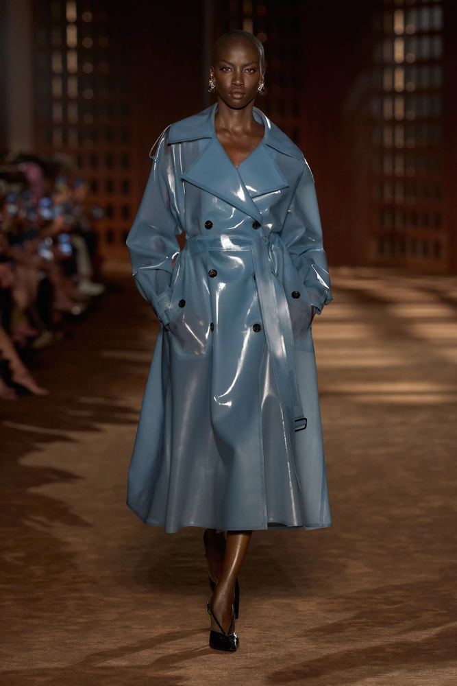 Sky-blue tinted latex trench coat with a glossy wet-look finish, Ferragamo S/S 27, Milan.